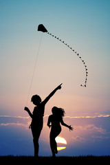 sisters with kite at sunset