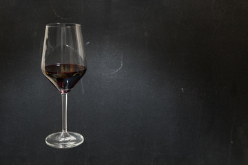 Glass of red wine on dark chalkboard