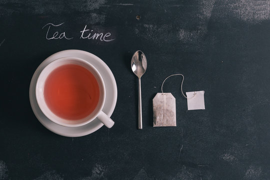 Tea with ingredients on dark chalkboard