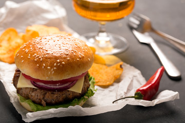 Hamburger with meat cutlet. Potato chips and beer