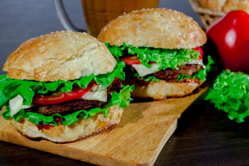 beer and homemade burgers buns with beef patties and fresh salad ingredients