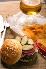 Hamburger with meat cutlet. Potato chips and beer