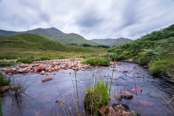 Grüne Landschaft und Bächlein in den Highlands, Schottland