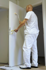 Handwerker beim lackieren einer Tür in einem Bürogebäude