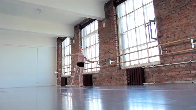 Young female ballet dancer exercising in ballet class