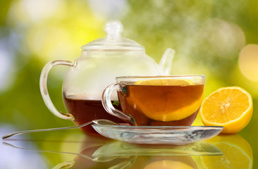 image of cups with tea and lemon on a green background close-up