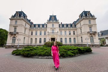 Obraz premium young girl in pink dress near monumental castle