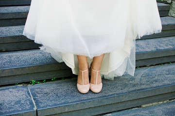 Fototapeta na wymiar Bride shows her elegant shoes on stairs