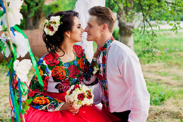 Amazing bride is sitting on swing with her groom
