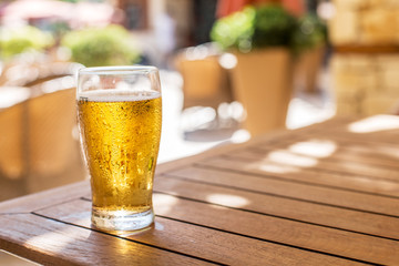 Glas helles Bier auf dem Holztisch.