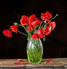 Fototapeta na wymiar Bouquet of poppy flowers in the vase on the wooden table.
