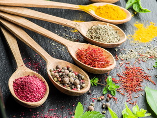 Assortment of colorful spices in the wooden spoons.