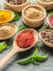 Assortment of colorful spices in the wooden spoons.