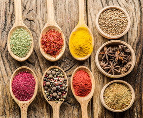 Assortment of colorful spices in the wooden spoons.