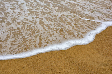 Fototapeta na wymiar Sea water moving on the sand beach in Ilhabela, Sao Paulo