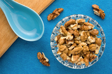 Walnuts. Top view of wooden Board and blue background. For kitchen and menu 