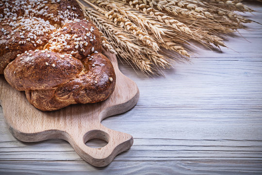 Carving board wheat rye ears long loaf on wooden background food