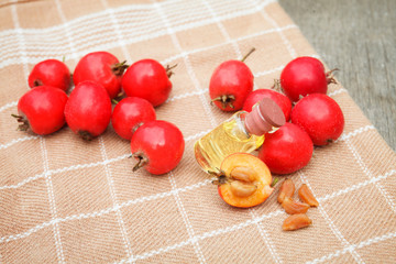 hawthorn seed oil container on napkin on wooden background
