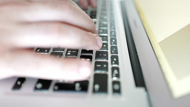 Accelerated footage of man hands writing on a laptop keyboard