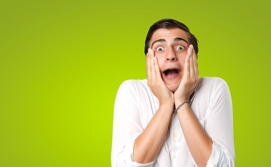 Amazed young man on green background