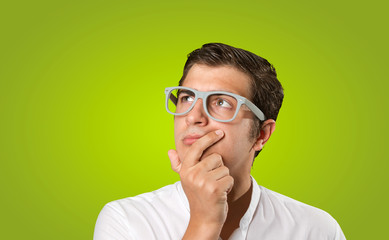 Close up of a young man wondering on green background