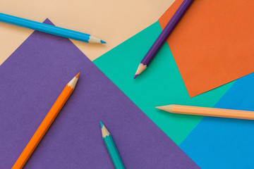 Background of colored paper and pencils