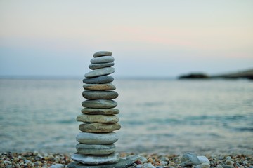 Tower of stones on a beach at sunset