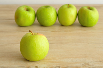 A green apple displayed on a wooden background 
