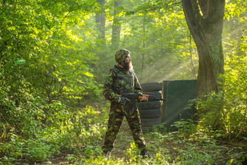 Soldier with rifle in forest