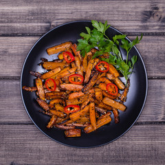 Roasted carrots in black plate, close up