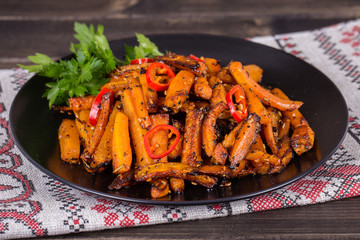 Roasted carrots in black plate, close up