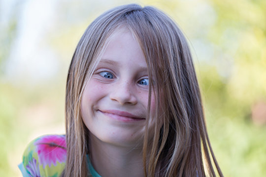 Beautiful cross-eyed young girl outdoors, portrait children close up
