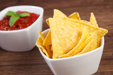 Salted potato crisps and sauce in bowls on board, concept of unhealthy food