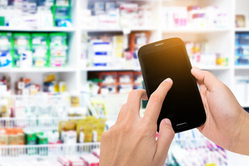 hand holding smart phone in pharmacy drugstore
