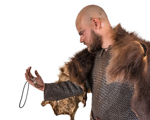 Scandinavian warrior in a bearskin, examines the decoration in the form of a bear tooth. Isolated...
