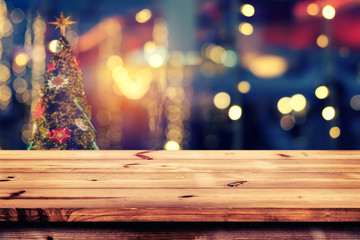 Top of wood table with christmas abstract background light bokeh from Xmas tree at night party in winter - Empty ready for your product display or montage. vintage color tone