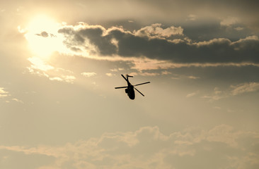 Fototapeta na wymiar IAR Puma elicopter silhouette flying in the cloudy sky, stunt aerobic