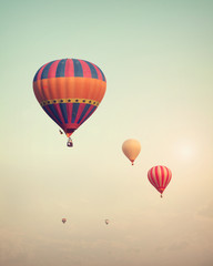 Vintage hot air balloon flying on sky with fog - retro filter effect style