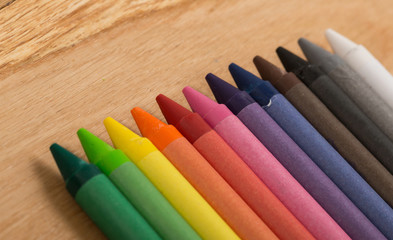 The colorful crayon on the wooden background