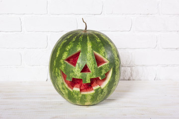 Smiling face of a water-melon on a Halloween like a pumpkin for