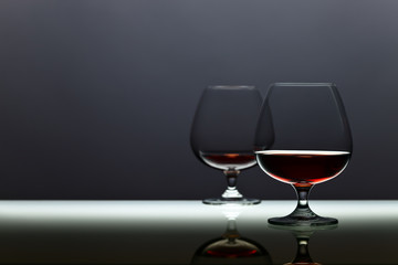 Two snifters of brandy on glass table