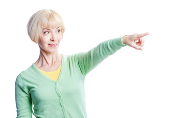 Just look at this! Advertising your product. Amazed middle aged woman looking and pointing away. Isolated on white.