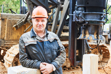 construction worker in front of pile driver machine