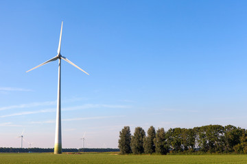 Wind turbine spinning with in a green countryside environment