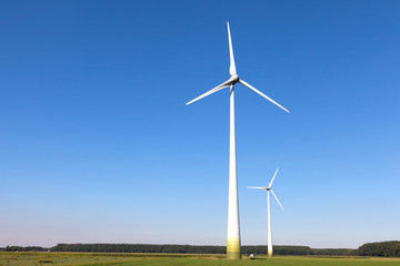 Wind turbine spinning with in a green countryside environment