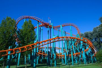 Orange rollercoaster with blue sky in the background
