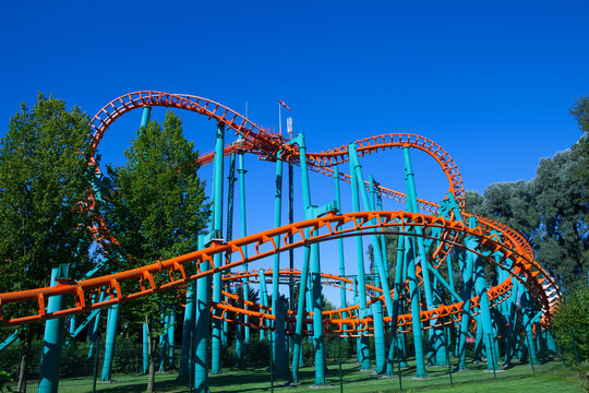 Orange rollercoaster with blue sky in the background
