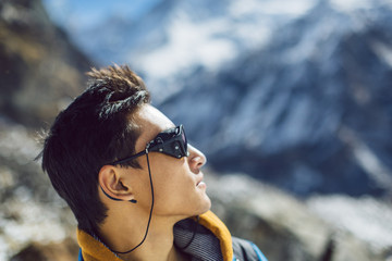 Profile portrait of young Sherpa wearing protective sunglasses in Himalayas