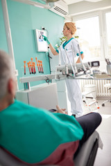 Obraz premium Female dentist examining dental X-ray