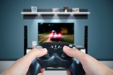 Hands hold the game controller. Man playing a car racing on TV